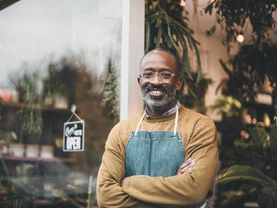 Man smiling in front of his small business. Man smiling in front of his small business.